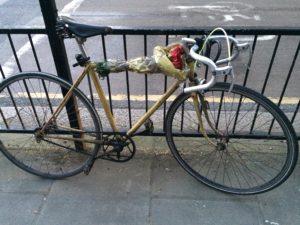 yellow bike with roses tied to its center pole